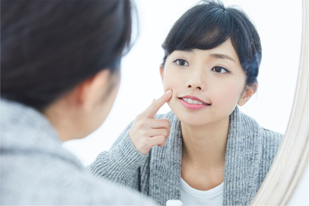 鏡で歯並びを確認する女性